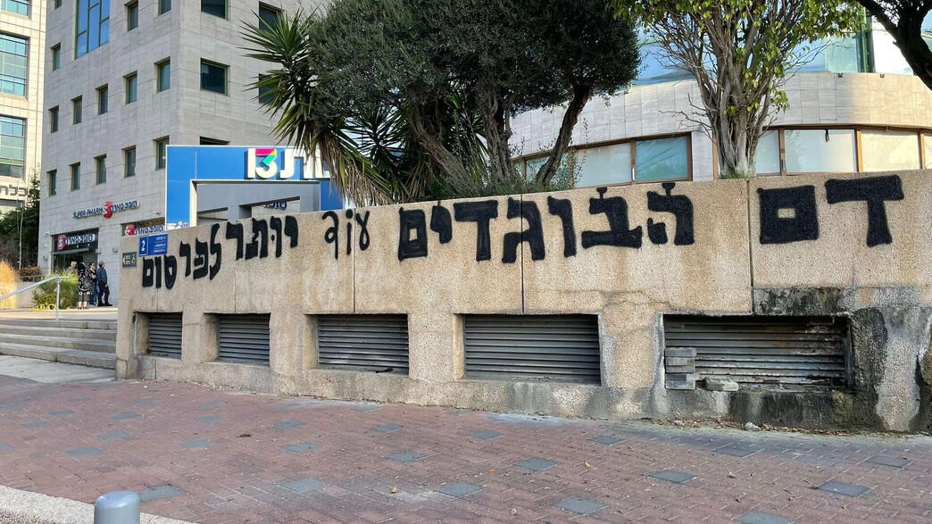 "דם הבוגדים עוד יותר לפרסום" | כתובת הגרפיטי הראשונה שחדי ריסס בכניסה לבניין "רשת 13" ברמת החייל בתל אביב, 20.11.2025 | (צילום מתוך רשת X: לפי סעיף 27א' לחוק זכויות היוצרים)