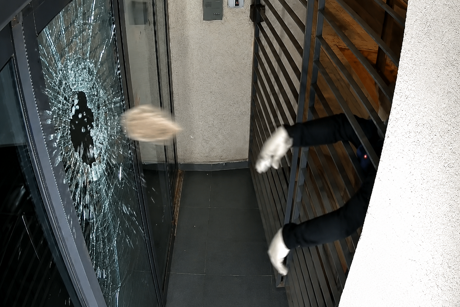 ניפוץ דלת הכניסה למערכת עיתון "הארץ" בידי רעול פנים, 08.07.2026 | (צילום ממצלמת האבטחה)